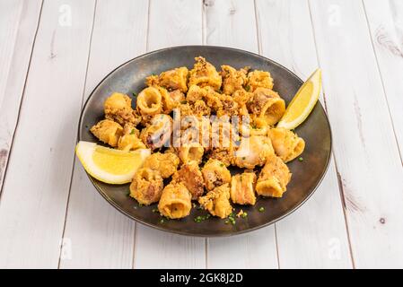 Calmar haché pané avec de la farine et des oeufs et poêlé dans l'huile d'olive avec du citron pour assaisonner Banque D'Images