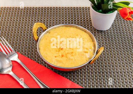 Poulet korma curry doux à la noix de coco déchiquetée dans un saladier en métal populaire sur une nappe de restaurant Banque D'Images