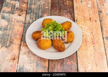 Recette pour la cuisine fusion croquettes farcies de chipotle et de crème de noix de coco sur une assiette blanche Banque D'Images