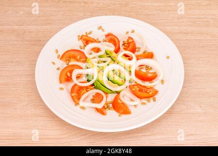 salade d'avocat simple avec rondelles d'oignon blanc, tomates et graines de tournesol pelées Banque D'Images