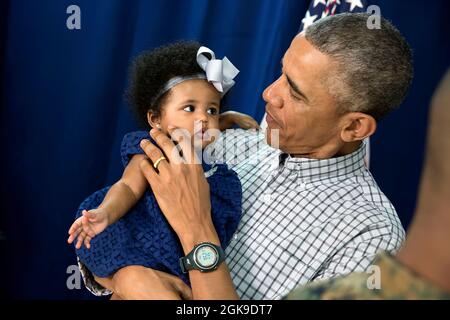 Le président Barack Obama tient une jeune fille lors d'une rencontre avec le personnel de la Marine et leurs familles à la base du corps des Marines à Hawaï le jour de Noël, le 25 décembre 2014. (Photo officielle de la Maison Blanche par Pete Souza) cette photo officielle de la Maison Blanche est disponible uniquement pour publication par les organismes de presse et/ou pour impression personnelle par le(s) sujet(s) de la photo. La photographie ne peut être manipulée d'aucune manière et ne peut pas être utilisée dans des documents commerciaux ou politiques, des publicités, des courriels, des produits, des promotions qui, de quelque manière que ce soit, suggèrent l'approbation ou l'approbation du Président, de l'IF Banque D'Images