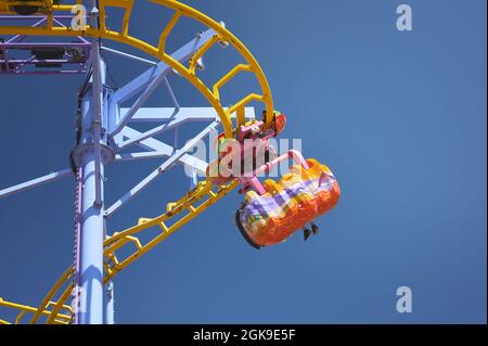 détail des personnes qui voyagent en montagnes russes dans un parc d'attractions Banque D'Images