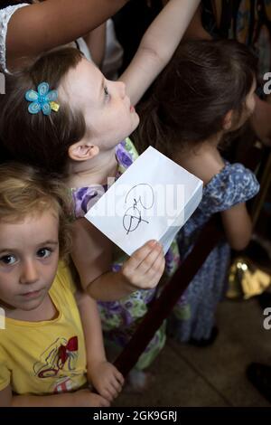 Une jeune fille tient un morceau de papier avec la signature du président Barack Obama lors d'une rencontre avec le personnel et leurs familles à l'ambassade des États-Unis à Rangoon, en Birmanie, le 19 novembre 2012. (Photo officielle de la Maison Blanche par Pete Souza) cette photo officielle de la Maison Blanche est disponible uniquement pour publication par les organismes de presse et/ou pour impression personnelle par le(s) sujet(s) de la photo. La photographie ne peut être manipulée d'aucune manière et ne peut pas être utilisée dans des documents commerciaux ou politiques, des publicités, des courriels, des produits, des promotions qui, de quelque manière que ce soit, suggèrent une approbation ou un endosperme Banque D'Images