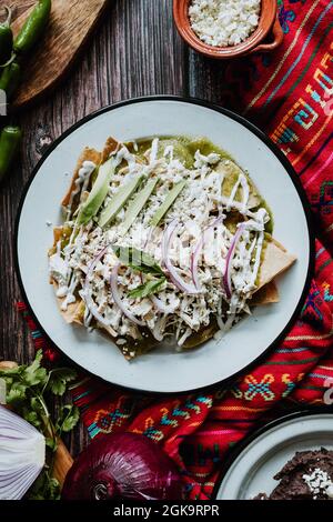 chilaquiles mexicaines avec poulet et sauce verte épicée petit-déjeuner traditionnel au Mexique. Vue horizontale sur le dessus Banque D'Images