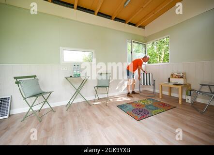 07 septembre 2021, Hessen, Schöneck-Kilianstädten: Uwe Christof se dresse dans sa petite Maison, qui est située dans son jardin de lotissement. Depuis des années, le spécialiste INFORMATIQUE de la retraite anticipée fait campagne pour ce qu'on appelle les petites maisons, essentiellement transportables qui, malgré leur faible encombrement, sont censées offrir à leurs habitants tout ce dont ils ont besoin pour vivre et peuvent être mis en place partout où cela est permis et les propriétaires aiment cela. À Hesse aussi, cela pourrait se transformer en une forme de vie pour l'avenir. (À dpa 'petites maisons avec un grand avenir? Les petites maisons sont également en demande dans la série Hesse Banque D'Images