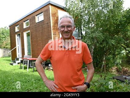 07 septembre 2021, Hessen, Schöneck-Kilianstädten: Uwe Christof se dresse devant sa petite Maison, située dans son jardin. Depuis des années, le spécialiste INFORMATIQUE de la retraite anticipée fait campagne pour ce qu'on appelle les petites maisons, essentiellement transportables qui, malgré leur faible encombrement, sont censées offrir à leurs habitants tout ce dont ils ont besoin pour vivre et peuvent être mis en place partout où cela est permis et les propriétaires aiment cela. À Hesse aussi, cela pourrait se transformer en une forme de vie pour l'avenir. (À dpa 'petites maisons avec un grand avenir? Les petites maisons aussi en demande à Hesse' - S. Banque D'Images