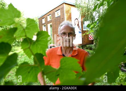 07 septembre 2021, Hessen, Schöneck-Kilianstädten: Uwe Christof se dresse devant sa petite Maison, située dans son jardin. Depuis des années, le spécialiste INFORMATIQUE de la retraite anticipée fait campagne pour ce qu'on appelle les petites maisons, essentiellement transportables qui, malgré leur faible encombrement, sont censées offrir à leurs habitants tout ce dont ils ont besoin pour vivre et peuvent être mis en place partout où cela est permis et les propriétaires aiment cela. À Hesse aussi, cela pourrait se transformer en une forme de vie pour l'avenir. (À dpa 'petites maisons avec un grand avenir? Les petites maisons aussi en demande à Hesse' - S. Banque D'Images