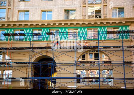 Saint-Pétersbourg, Russie - 09 juillet 2021 : des constructeurs effectuent des travaux de façade sur un nouveau bâtiment résidentiel de plusieurs étages à Saint-Pétersbourg Banque D'Images