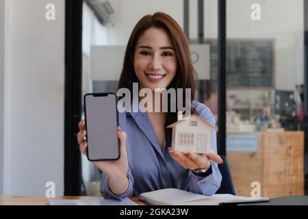 Concept Smart Home. Femme montrant l'application Smart Home sur un smartphone Banque D'Images