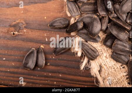 Graines de tournesol noires frites éparpillées sur la table, gros plan, mise au point sélective Banque D'Images