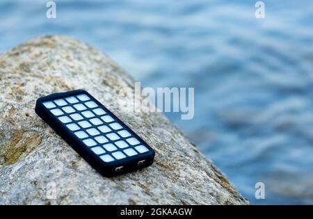 USB solaire portable situé sur une pierre sur la plage. Énergies alternatives. ECO Banque D'Images