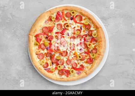 Vue de dessus d'une petite pizza avec saucisse fine, poivron, olives et oignon Banque D'Images
