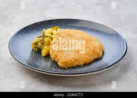 Schnitzel de porc avec pomme de terre et concombre mariné dans une sauce moutarde Banque D'Images