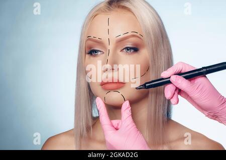 Belle femme blonde avec des marques pour la chirurgie plastique sur son visage Banque D'Images