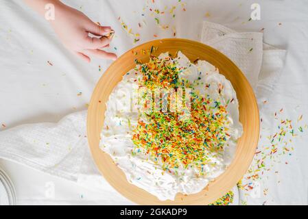 Saupoudrer les enfants sur un gâteau Banque D'Images