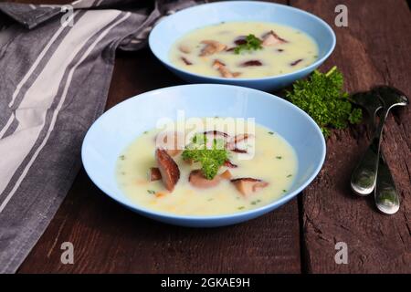 Soupe crémeuse aux champignons porcini et aux herbes sur une table en bois Banque D'Images