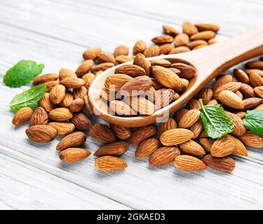 Amandes en cuillère brune sur fond de bois Banque D'Images