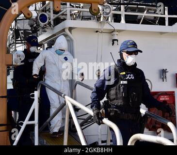 Les membres de l'équipage du Cutter de la Garde côtière Heriberto Hernandez déchargent plus de 200 kilogrammes de cocaïne, d'une valeur de plus de 5.6 millions de dollars, et transfèrent trois contrebandiers présumés, un vénézuélien et deux Dominicains, à des agents fédéraux de la Force de grève du corridor des Caraïbes le 2 mars 2021 à la base de la Garde côtière San Juan. Le buste est le résultat d'une interdiction en mer par le Cutter de la Garde côtière Richard Dixon et des organismes partenaires dans la mer des Caraïbes près des îles Vierges américaines le 23 février 2021. Banque D'Images