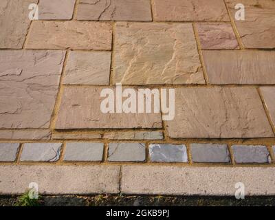 Allée bordée de blocs gris et de pavés de couleur terre Banque D'Images