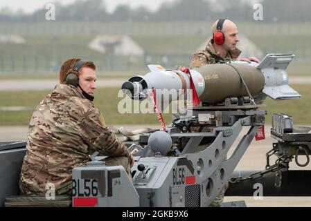 Sgt. Tech. De la Force aérienne des États-Unis Jeffrey Cole, 48e chef d'équipe principal de la Section de normalisation des armes, Et l'avionneur principal Aaron Santos, 48e membre de l'équipage principal de la Section de normalisation des armes, utilisent un chariot élévateur à bombe pour transporter une bombe GBU-12 guidée au laser à bord de l'avion pendant un exercice de virage de combat intégré à la Royal Air Force Lakenheath, en Angleterre, le 2 mars 2021. Les GBU-12 ont été déposés dans un champ de bombardement militaire au large de la côte écossaise, l'un des seuls endroits du Royaume-Uni où les forces des États-Unis, du Royaume-Uni et de l'OTAN peuvent s'entraîner avec des munitions aériennes à la surface. Banque D'Images