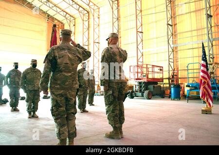 Col. Mark Coble et Sgt. Le Maj. John Shannon, 734e Groupe de soutien régional, salue les couleurs de l'unité après les avoir défait lors de la cérémonie de transfert d'autorité à la base aérienne d'Al Asad, en Iraq, le 3 mars 2021. L'unité de la Garde nationale de l'Iowa effectuera des fonctions d'intégrateur de soutien opérationnel de base et de services de camp de base à l'appui de l'opération Resolve inhérente. Banque D'Images