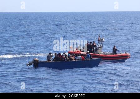 L'équipage du petit bateau de la Garde côtière Joseph Tezanos est sur place avec l'un des deux voyages illégaux qui ont été interdictés par le Cutter, dans des cas séparés, dans les eaux du passage de Mona le 6 mars 2021. Les 58 migrants des deux interdépendances ont été rapatriés en mer dans un navire de la marine de la République dominicaine près de la République dominicaine le 7 mars 2021. Banque D'Images