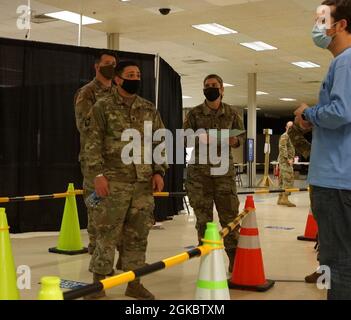 Garde nationale de l'armée du Kentucky SPC. Paulo Salazar, avec le 101e détachement opérationnel du poste de commandement principal, 75e commandement de la troupe, coordonne avec un membre du personnel civil de Med Center Health pendant le déploiement du vaccin COVID-19 à Bowling Green, Ky., le 6 mars 2021. Des soldats de tout le Kentucky participent au déploiement de vaccins à Bowling Green, Lexington et Louisville. Banque D'Images