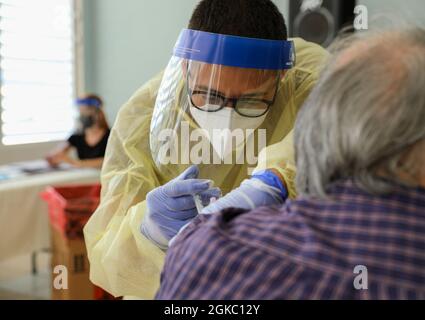 PV2 Joe Díaz, un medic de la Garde nationale de Porto Rico, vaccine un des résidents de l'Egida del Policía à Trujillo Alto, Porto Rico, le 8 mars 2021. Les soldats et les aviateurs affectés à la Force opérationnelle interarmées - Porto Rico poursuivent leur engagement sans fin à vacciner tous les citoyens âgés de l'île. Banque D'Images