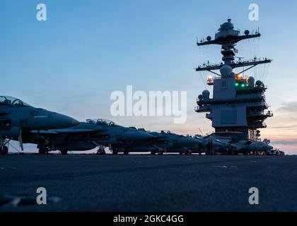 F/A-18e/F Super Hornets attachés aux « Flying Eagles » de l’Escadron d’appui Strike (VFA) 122, et un E-2C Hawkeye attaché aux « Bear Aces » de l’Escadron de commandement et de contrôle aéroporté (VAW) 124 reposent sur le pont de vol de l’USS Gerald R. Ford (CVN 78) le 9 mars 2021. Ford est en cours dans l'océan Atlantique en menant des qualifications de transporteur. Banque D'Images