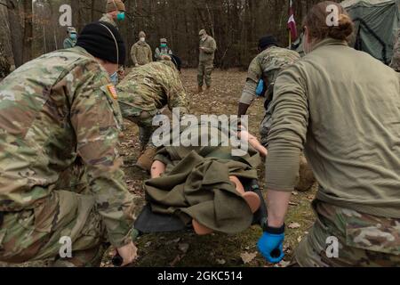 Les soldats de l'armée américaine affectés au 160e détachement médical l'équipe chirurgicale de réanimation avancée transporte un mannequin simulé pendant un exercice de soins médicaux et chirurgicaux d'urgence conjoint avec l'équipe chirurgicale terrestre du 86e groupe médical de l'US Air Force à l'aire d'entraînement de Breitenwald, Landstuhl, Allemagne, le 9 mars 2021. L'exercice conjoint comprenait la réanimation et les soins d'urgence pour les patients simulés blessés ou malades critiques dans un environnement en dehors des capacités établies de déplacement des patients. Banque D'Images