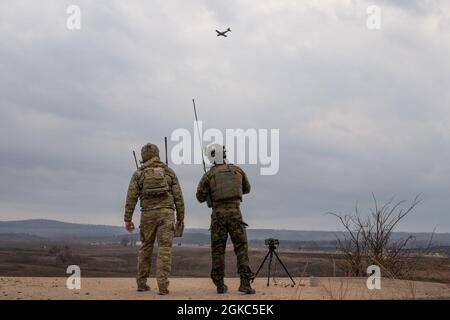 Tech. Sgt. Curtis Hinkley, un 6e Escadron d’entraînement au combat, instructeur du détachement 2 (à gauche), Et un officier du parti tactique estonien de contrôle aérien (à droite) inscrit au cours de qualification du contrôleur d'attaque du terminal commun (JTACQC), regardez un Raider A-90 de Blue Air Training engager une cible lors des essais finaux à Razorback Range près de fort Smith, Arr., le 9 mars 2021. Le programme Blue Air Training, ainsi que Les Chasseurs A-10 de la base aérienne de Whiteman, ont fourni un soutien en direct en direct à bord de l'avion aux étudiants du cours, qui est organisé par le 137e vol d'entraînement au combat de la base nationale de guar Will Rogers Air à Banque D'Images