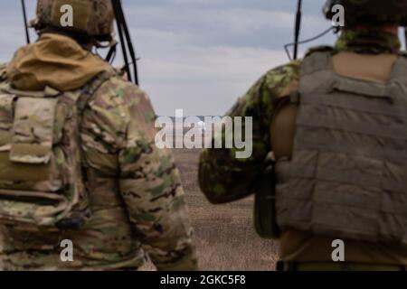 Tech. Sgt. Curtis Hinkley, un 6e Escadron d'entraînement au combat, instructeur du détachement 2 (à gauche) et un officier du parti tactique estonien du contrôle aérien inscrit au cours de qualification du contrôleur d'attaque du terminal conjoint (JTACQC), organisé par le 137e vol d'entraînement au combat de la base de Will Rogers Air de la Garde nationale à Oklahoma City, Observez une bombe d'entraînement non explosive BDU-33 heurtée près d'une cible à la chaîne Razorback près de fort Smith, Arr., le 9 mars 2021. La BDU-33, abandonnée par un Raider A-90 de Blue Air Training, présente des caractéristiques de vol et de livraison semblables à celles de son homologue de combat, en fournissant Banque D'Images