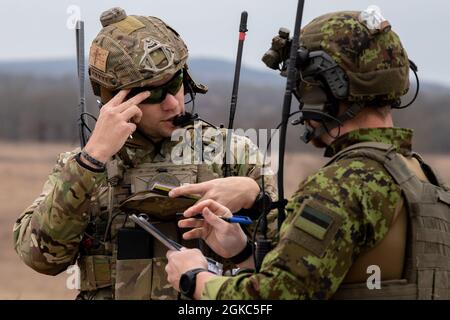 Tech. Sgt. Curtis Hinkley, un instructeur du détachement 2 du 6e Escadron d'entraînement au combat, donne des instructions à un étudiant estonien du contrôle aérien tactique (TACP) inscrit au cours de qualification du contrôleur d'attaque de terminal conjoint (JTACQC), organisé par le 137e vol d'entraînement au combat (137e FCT) de la base de la Garde nationale Will Rogers Air à Oklahoma City, À Razorback Range, près de fort Smith, en Arkansas, le 9 mars 2021. Le TACP estonien est le premier à compléter le commandement de combat aérien JTACQC d'une nation partenaire de l'OTAN depuis que le 137e CTF a commencé à accueillir des étudiants internationaux. Banque D'Images