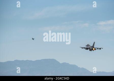 Un F-16 Viper survole la ligne aérienne pendant le drapeau rouge 21-2 à la base aérienne de Nellis, Nevada, le 9 mars 2021. Le drapeau rouge 21-2 comprenait deux escadrons de chasseurs de la 20e Escadre de chasseurs, un pour escorter des avions à l'entrée et à la sortie de l'aérodrome et un pour exécuter la suppression des défenses aériennes ennemies. Le F-16 est une cellule multirôle, utilisée dans divers ensembles de missions dans des situations exigeant à la fois un conflit air-air et air-sol. Banque D'Images