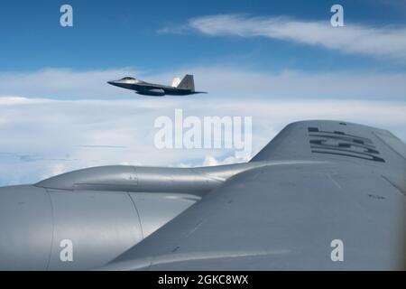 Un Raptor F-22 de la Garde nationale aérienne d'Hawaï vole avec un KC-135 Stratotanker du 203e Escadron de ravitaillement aérien le 10 mars 2021, près d'Oahu, à Hawaï. Les rapaces ont reçu une formation de F-16 pour combattre les faucons de la base aérienne d'Eielson, en Alaska, au cours d'une séance finale d'entraînement pour l'exercice Pacific Raptor. Les rapaces hawaïens sont exploités par des gardes et des aviateurs actifs des escadrons de chasseurs 199e et 19e. Banque D'Images