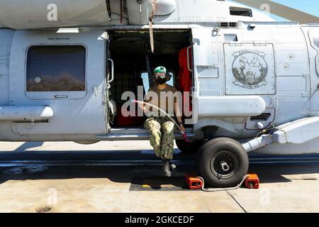 210311-N-YD864-1028 STATION NAVALE MAYPORT (Floride) (le 11 mars 2021) le mécanicien de structures aéronautiques de 2e classe Kimberly Espinoza, affecté aux « Airwolves » de l'escadron de frappe maritime des hélicoptères (HSM) 40, présente une image entre les vérifications d'entretien effectuées à la station navale Mayport. Le HSM 40 est l'un des deux escadrons de remplacement de flotte MH-60R qui fournissent de l'entraînement et du soutien à l'escadre de frappe maritime des hélicoptères de l'Atlantique. Banque D'Images