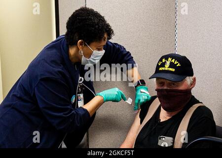 Un membre du personnel de la clinique administre une dose du vaccin COVID-19 dans le bras de l'ancien maître Petty Officer John Milliken au Central Virginia va Health Care System (CVHCS) Fredericksburg-Mary Washington Community-Based ambulatoire Clinic (CBOC), le 11 mars 2021. Milliken, qui a servi à bord de neuf navires de la Marine après s'être enrôler à l'âge de 17 ans, a grandi au Colorado avant de rejoindre la Marine en 1959. Le personnel des cliniques de Richmond, Fredericksburg, Charlottesville et Emporia vaccine les anciens combattants depuis le lancement des cliniques de vaccins COVID-19 en janvier dernier. À ce stade, CVHCS Banque D'Images