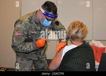 PFC. Jonathan Miller, un medic de combat avec Headquarters and Headquarters Company, 2/112th Infantry Regiment, Pennsylvania National Guard, administre un vaccin COVID-19 à Lancaster-Lebanon IU13 à Lancaster, Pennsylvanie, le 12 mars 2021. Près de 90 membres de la Garde nationale de Pennsylvanie soutiennent les cliniques de vaccination COVID-19 pour les enseignants et le personnel scolaire dans sept sites de Pennsylvanie. Banque D'Images