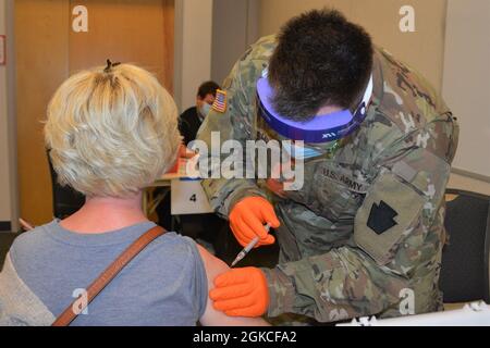 PFC. Jonathan Miller, un medic de combat avec Headquarters and Headquarters Company, 2/112th Infantry Regiment, Pennsylvania National Guard, administre un vaccin COVID-19 à Lancaster-Lebanon IU13 à Lancaster, Pennsylvanie, le 12 mars 2021. Près de 90 membres de la Garde nationale de Pennsylvanie soutiennent les cliniques de vaccination COVID-19 pour les enseignants et le personnel scolaire dans sept sites de Pennsylvanie. Banque D'Images