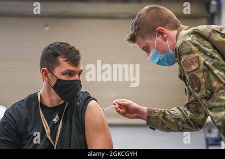 Le capitaine Matthew Major, 421e Escadron de chasseurs, reçoit sa deuxième dose du vaccin Moderna COVID-19 du Senior Airman Benjamin Gallagher, 75e Groupe médical, le 12 mars 2021, à la base aérienne Hill, Utah. Le 75e groupe médical distribue le vaccin sur une base de distribution par roulement, conformément au plan de vaccination COVID-19 et au schéma de population du ministère de la Défense. Banque D'Images