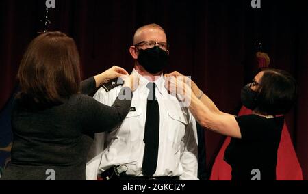 Le 13 mars 2021, le colonel Scott W. Hiipakka de la Garde nationale de l'Armée du Michigan est promu brigadier-général à l'école secondaire Milford à Highland. Ses épaules sont changées par cette sœur (à gauche) et sa belle-mère (à droite). La cérémonie s’est déroulée à l’alma mater de ses enfants, où il a passé du temps comme parent et membre actif de sa communauté. Banque D'Images