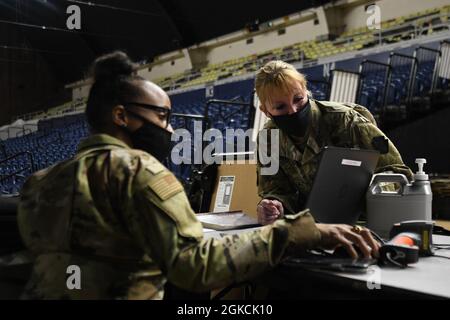 Le lieutenant-colonel Dee Watkins de l'armée américaine, à droite, officier du personnel de la Garde nationale de l'armée de Pennsylvanie, voit un ordinateur avec l'aviateur principal Joielle Cobb-Sanders, personnelliste, 127e Flight Service stations, Michigan Air National Guard, Dans le cadre du suivi des unités qui ont été traitées de la mission de la réaction du Capitole pour rentrer au District of Columbia Armory à Washington, D.C., le 13 mars 2021. On a demandé à la Garde nationale de continuer à soutenir les organismes fédéraux d'application de la loi en offrant un soutien en matière de sécurité, de communications, d'évacuation médicale, de logistique et de sécurité au district, St Banque D'Images