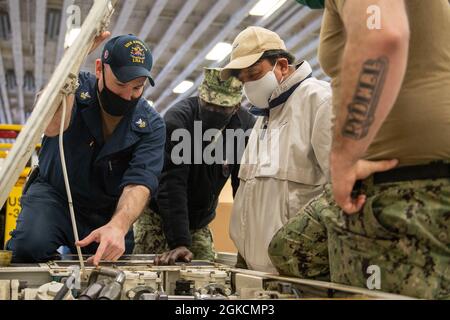 SASEBO (Japon) (15 mars 2021) les marins affectés au navire d'assaut amphibie déployé à l'avant USS America (LHA 6) effectuent l'entretien de l'équipement de soutien de l'aviation. L'Amérique, navire chef de file du America Amphiobie Ready Group, opère dans la zone de responsabilité de la 7e flotte des États-Unis afin d'améliorer l'interopérabilité avec les alliés et les partenaires et de servir de force de réaction prête à l'emploi pour défendre la paix et la stabilité dans la région Indo-Pacifique. Banque D'Images