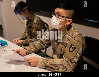 SPC de l'armée américaine. Aian Foronda, à droite, une Ewa Beach, Hawaii, native et infirmière affectée au 531e Centre hospitalier, filtre un membre de la communauté avant d'administrer un vaccin COVID-19 à la First Baptist Church of Lincoln Gardens COVID-19 Community vaccine Centre, gérée par l'État et appuyée par le gouvernement fédéral, à Somerset, New Jersey, le 15 mars 2021. Il faut généralement deux semaines après la vaccination complète pour que le corps puisse construire une protection contre le virus qui cause le COVID-19. Le Commandement du Nord des États-Unis, par l'entremise de l'Armée du Nord des États-Unis, demeure déterminé à fournir un soutien continu et souple du ministère de la Défense à la Banque D'Images