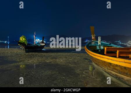 Nuit à Patong Beach, Phuket. Marée basse totale avec les bateaux à longue queue reposant sur le sable Banque D'Images