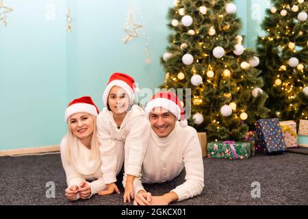 La famille, noël, x-mas, l'hiver, le bonheur et les gens concept - smiling family in santa helper chapeaux avec de nombreux coffrets cadeaux et des feux de Bengale Banque D'Images