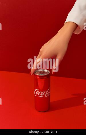 KIEV, UKRAINE - 7 septembre 2021. Les femmes manucures ont la main avec Coca Cola CAN sur fond rouge Banque D'Images