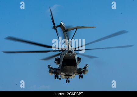 Un US Marine corps CH-53E Super Stallion avec la 1ère aile d'avions marins extrait des Marines avec 3d reconnaissance Battalion, 3d Marine Division, et des soldats de l'armée américaine avec le 1er Bataillon, 1er Groupe des forces spéciales (Airborne), pendant le Castaway 21.1 sur IE Shima, Okinawa, Japon, 17 mars 2021. Cet exercice a démontré la capacité du corps des Marines à s’intégrer à la force conjointe pour s’emparer et défendre des terrains maritimes clés, fournir un soutien de faible envergure et exécuter des feux de précision à longue portée à l’appui d’opérations navales à partir d’une base expéditionnaire avancée. Banque D'Images