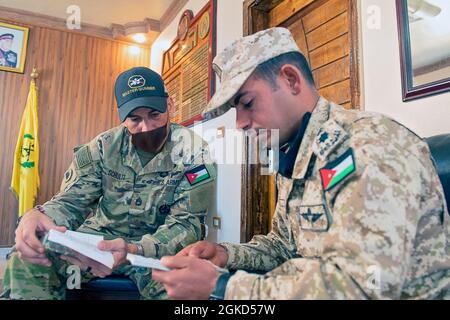 Sergent de l'armée américaine Davin Schultz, un maître-tireur de la 36e Division d'infanterie de Manor, Texas, compare des guides de campagne de poche avec le commandant des forces armées jordaniennes de la compagnie de réservoir d'unité du 3e Groupe de gardes-frontières, CPT. Salem Abu Nwaer, 17 mars 2021. Les soldats de la Force opérationnelle Spartan de la Division tactique- Jordanie ont conseillé et aidé les soldats du 3e Groupe de la Garde frontalière dans leur zone d'opérations avec de petites tactiques d'escouade, des compétences du personnel et l'habilitation de leurs officiers non commissionnés. Cette opportunité permet d'améliorer les compétences, l'interopérabilité et la capacité des partenaires, et renforce la durabilité Banque D'Images
