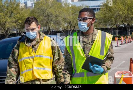 Le premier Airman Andrew Torres de la Force aérienne des États-Unis, 4e Groupe Medial, base aérienne Seymour Johnson, Caroline du Nord, et Airman Treshun Word, 366e Escadron de préparation médicale opérationnelle, base aérienne Mountain Home, Idaho, marchent sur les voies du NRG Community Vaccination Centre (CVC) à Houston, le 18 mars 2021. Des aviateurs de 14 bases aériennes différentes sont présents au CVC, à la demande du Commandement de combat aérien, pour aider à fournir des vaccins aux communautés mal desservies. Le Commandement du Nord des États-Unis, par l'entremise de l'Armée du Nord des États-Unis, demeure déterminé à fournir un soutien continu et souple au ministère de la Défense Banque D'Images